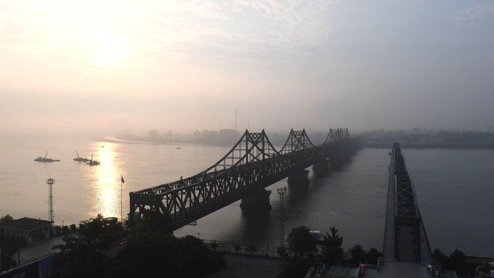 The North Korean town of Sinuiju (at rear) is seen behind the Friendship Bridge (L) which connects Sinuiju and the the Chinese border city of Dandon