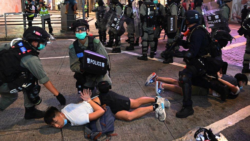 Police officers detain protesters in Hong Kong during a rally against the new national security law