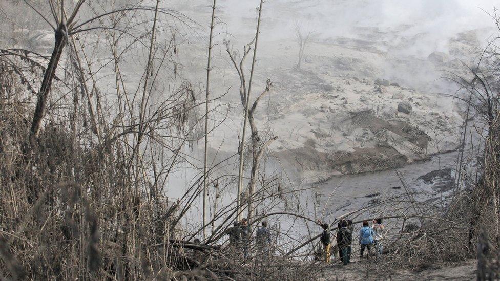 Villagers inspect the path of a pyroclastic flow from the eruption of Mount Sinabung in Gamber village, North Sumatra, Indonesia, Sunday, May 22, 2016.