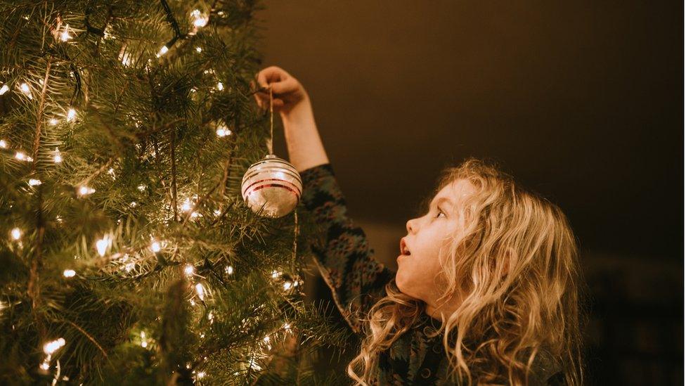 girl-decorates-christmas-tree.