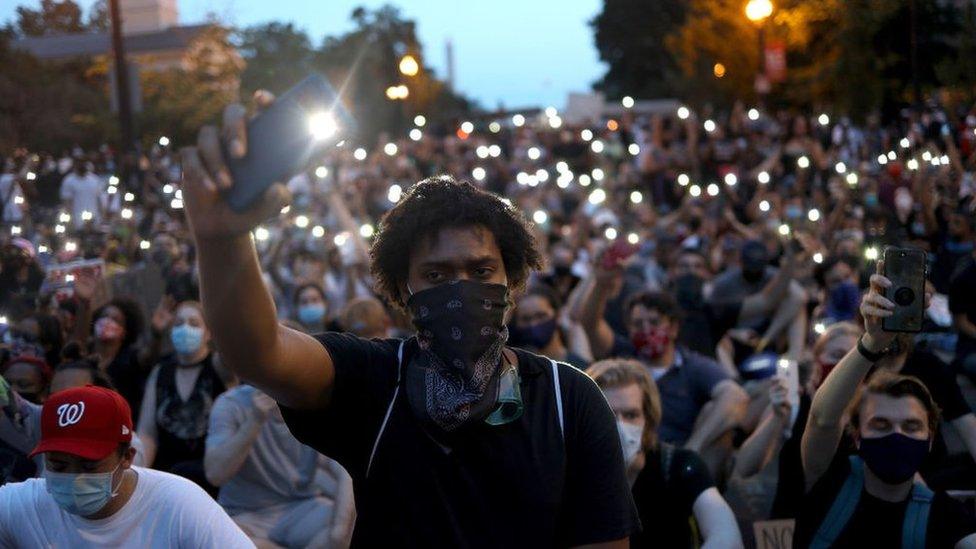 Demonstrators sing "Lean On Me" near the White House during a peaceful protest against police brutality and the death of George Floyd, on June 3, 2020 in Washington, DC