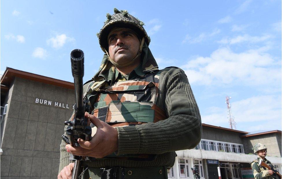 Indian paramilitary soldiers stand guard at a polling station in Srinagar on 9 April 2017.