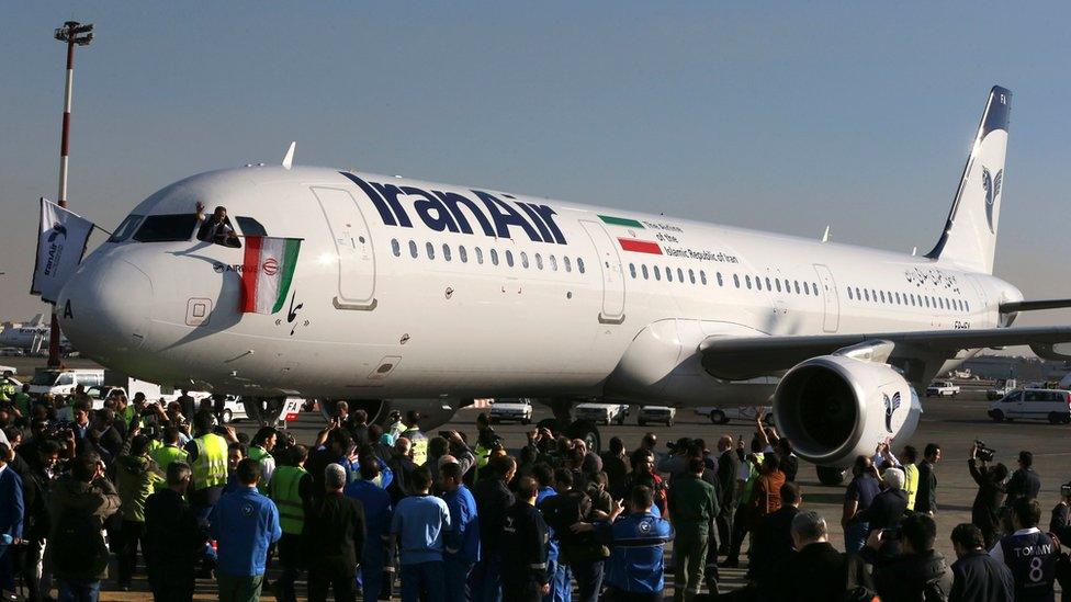 The pilot of IranAir's new Airbus plane waves a flag after landing at Mehrabad airport, in Tehran (12 January 2017)