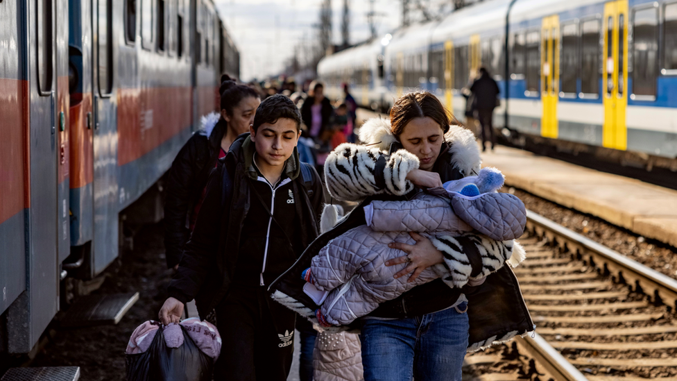 Hundreds of people arrive at a train station in Hungary after fleeing Ukraine