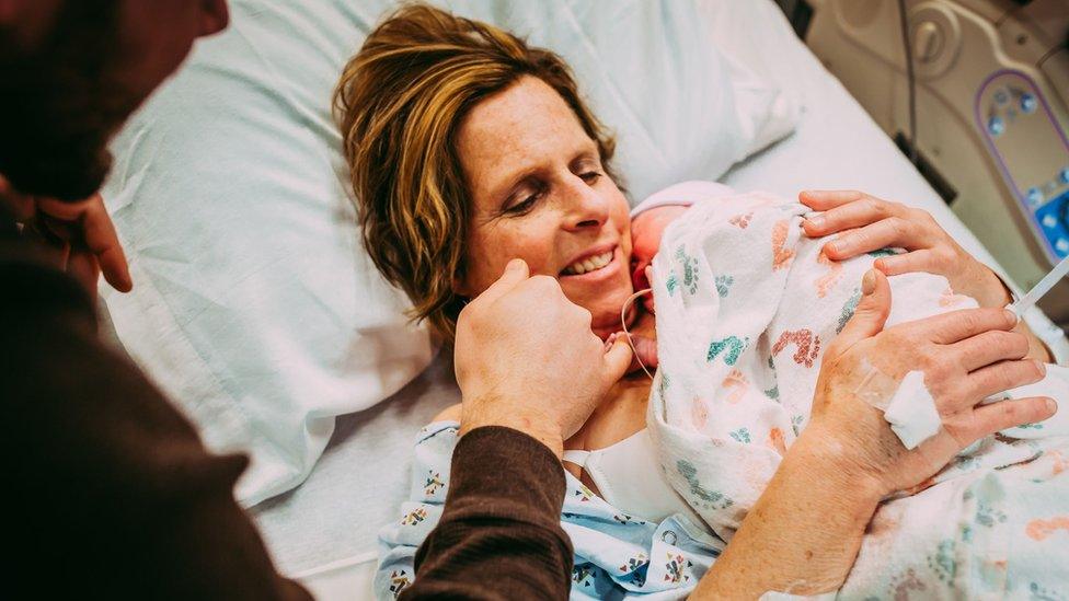 Woman, Cecil Eledge, holds her newborn granddaughter Uma.