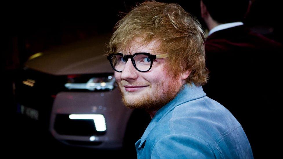 ed sheeran looks at camera in glasses