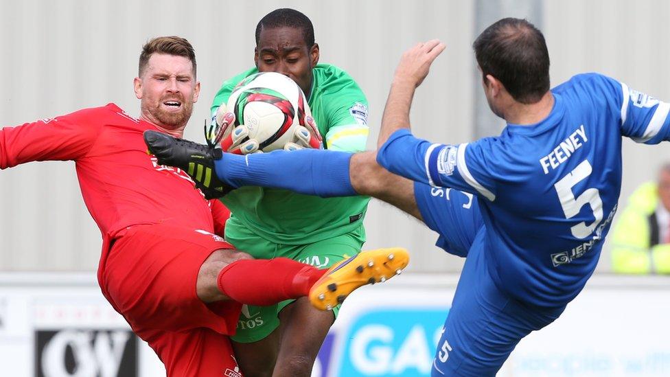 Ballinamallard goalkeeper Alvin Rouse grasps the ball ahead of Portadown's Gary Breen and home defender Stephen Feeney at Ferney Park