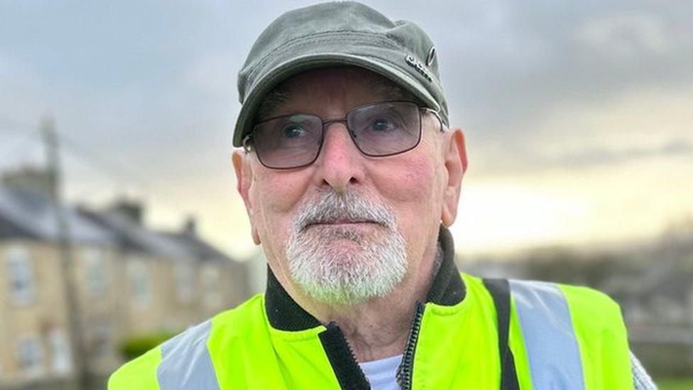 Close up of a man in a cap and high vis jacket