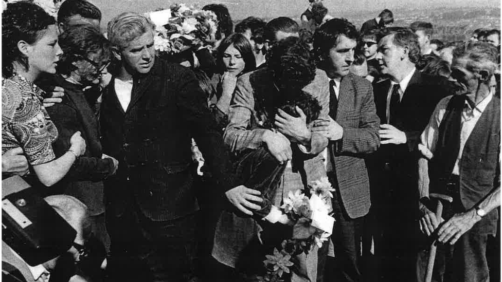 The image shows distraught members of Annette McGavigan's family at her graveside in Derry in 1971