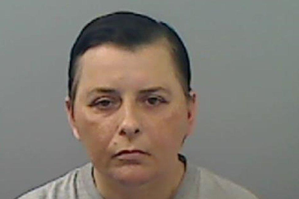 Mugshot of a woman with short black hair