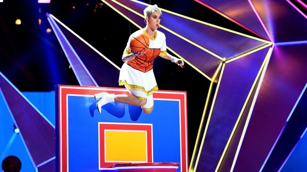 Katy Perry suspended over a basketball hoop mid performance