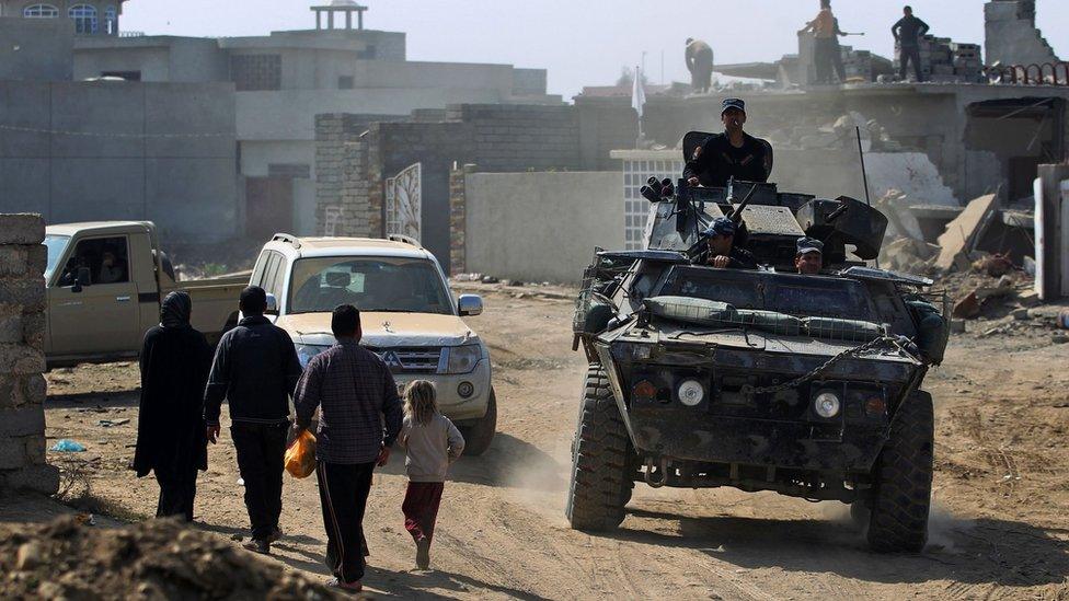 Iraqi forces patrol a street in the Jawsaq district, in south-western Mosul (28 February 2017)