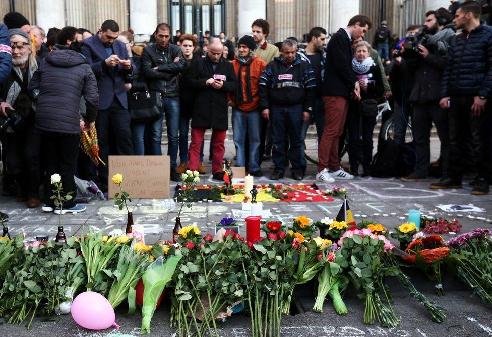 People leave tributes at the Place de la Bourse following attacks in Brussels