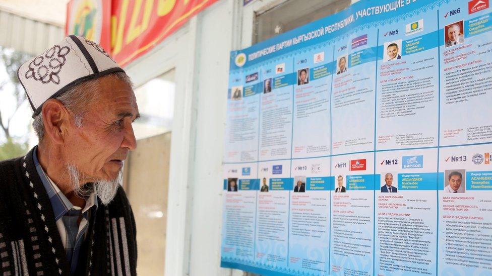 A Kyrgyz man studying information about various candidates. Fourteen parties are taking part in the parliamentary poll