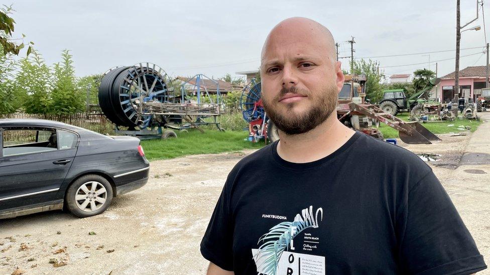 Cotton farmer Themis Apostolakis stands in front of his family farm