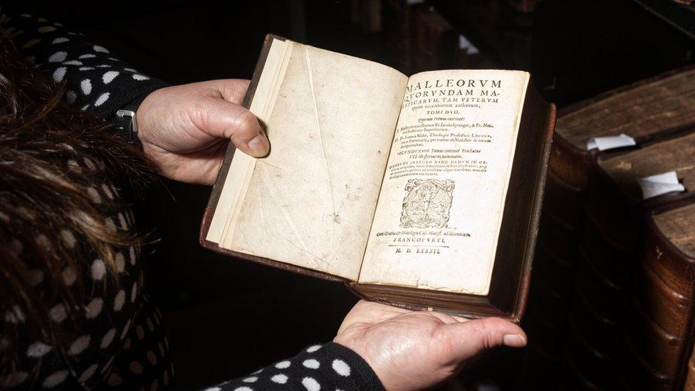 Dr Demelo holding one of the copies of the Malleus Maleficarum