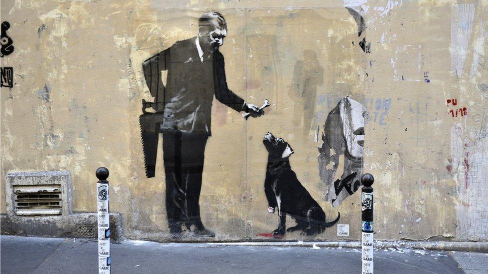 A recent artwork believed to be attributed to Banksy is of a man offering a dog a bone having first sawn the animal's leg off in the Sorbonne neighbourhood