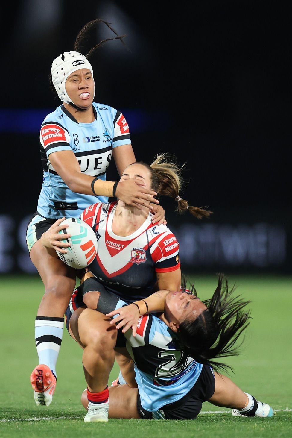 Isabelle Kelly of the Roosters makes a hit up and is tackled by Annessa Biddle and Chantay Kiria-Ratu of the Sharks during the NRLW preliminary final match in Gosford, Australia. Photo by Scott Gardiner
