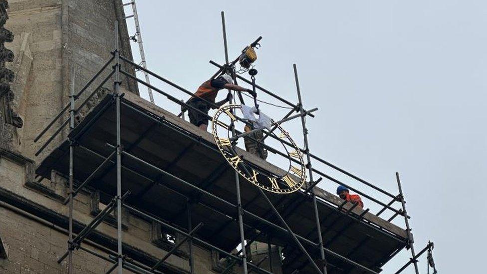 A clock being lifted into place