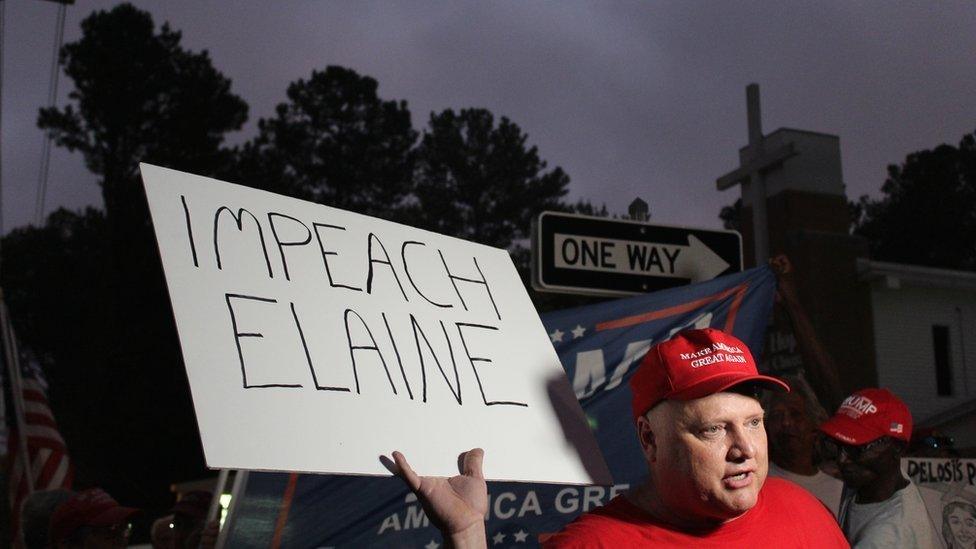 Trump supporter Richard Egger holding a sign saying "Impeach Elaine"