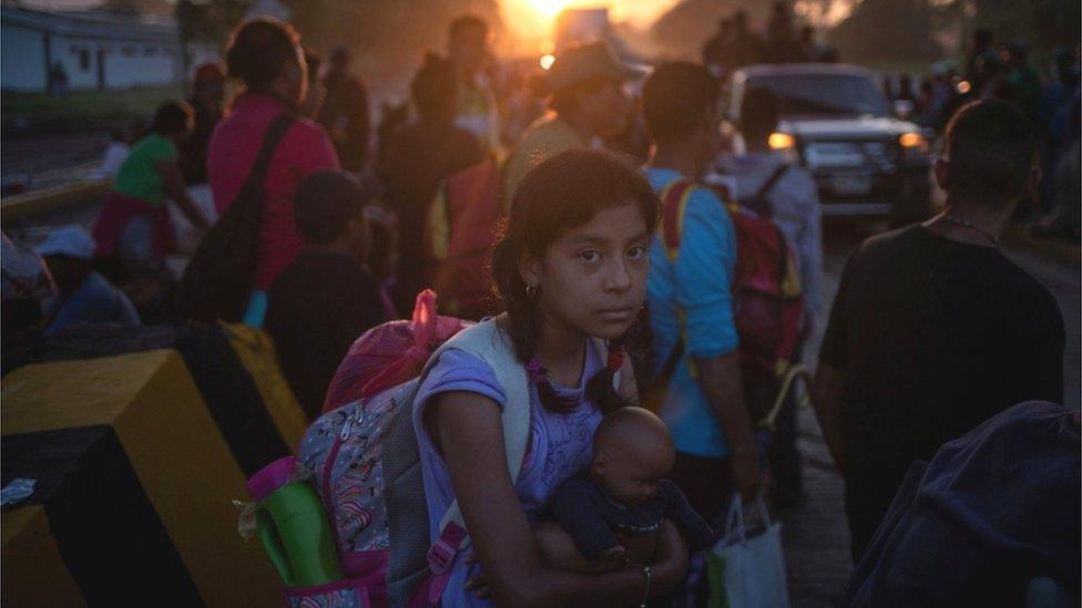 A girl traveling with a caravan of thousands of migrants from Central America en route to the United States holds her belongings while making her way to Mapastepec