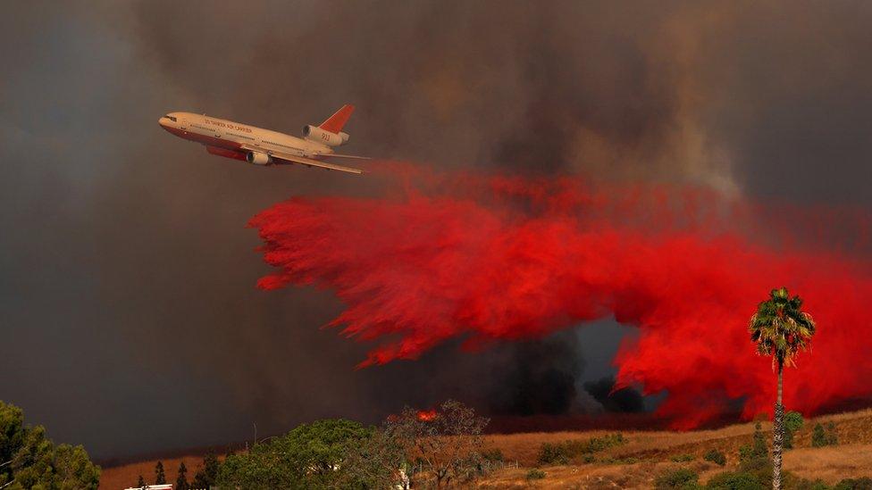 Plane dropping powder to try and stop the fire spreading