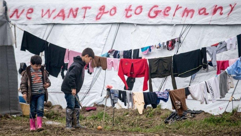 Children play in front of washing drying at the Idomeni refugee camp on the Greek Macedonia border on March 17, 2016 in Idomeni, Greece