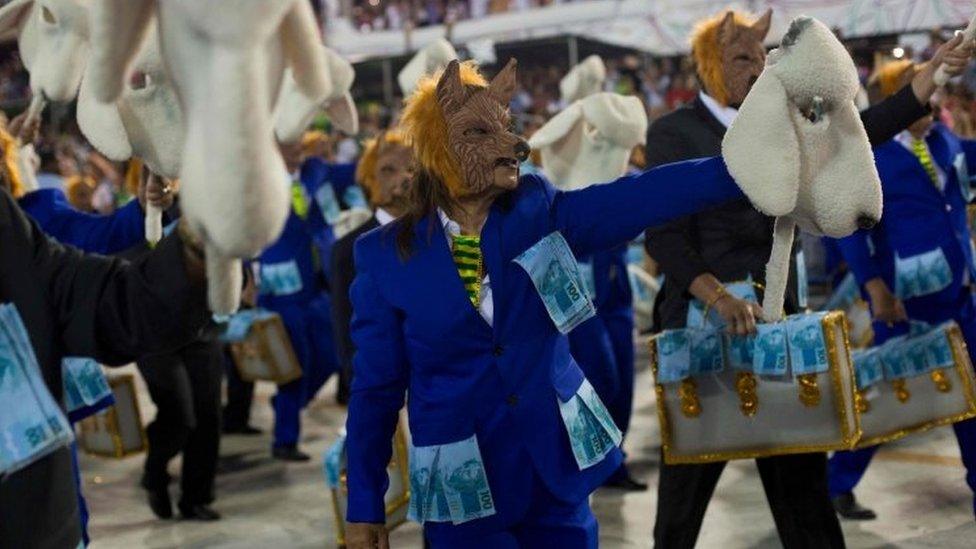 Government officials depicted as wolves in sheep's clothing with golden suitcases of money at Rio Carnival