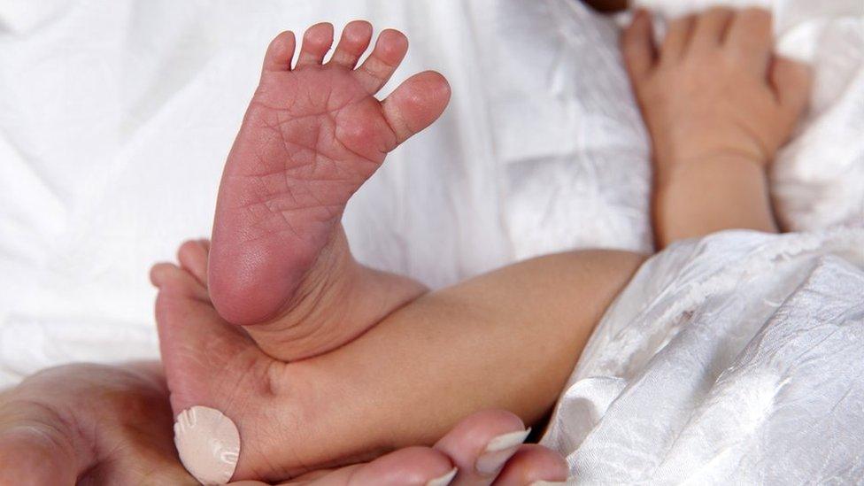 Newborn baby with a plaster on its heel