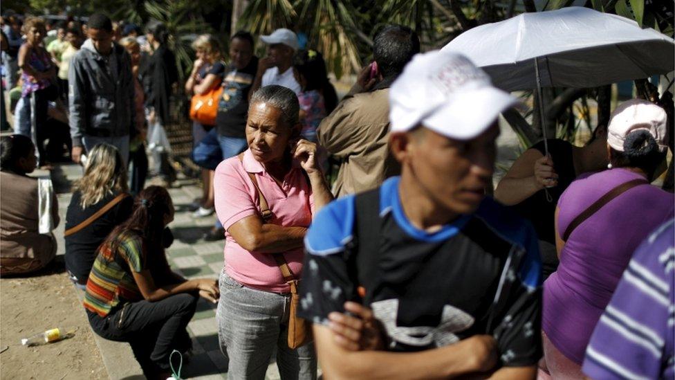 People line up to try to buy meat, outside a supermarket in Caracas, 16 January 2016.