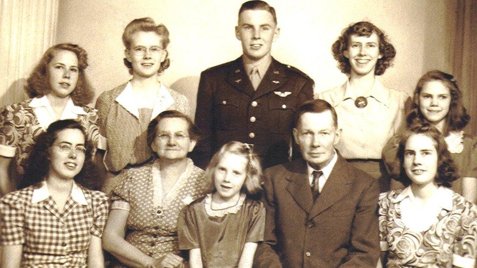 John Walker surrounded by seven of his eight sisters and his parents