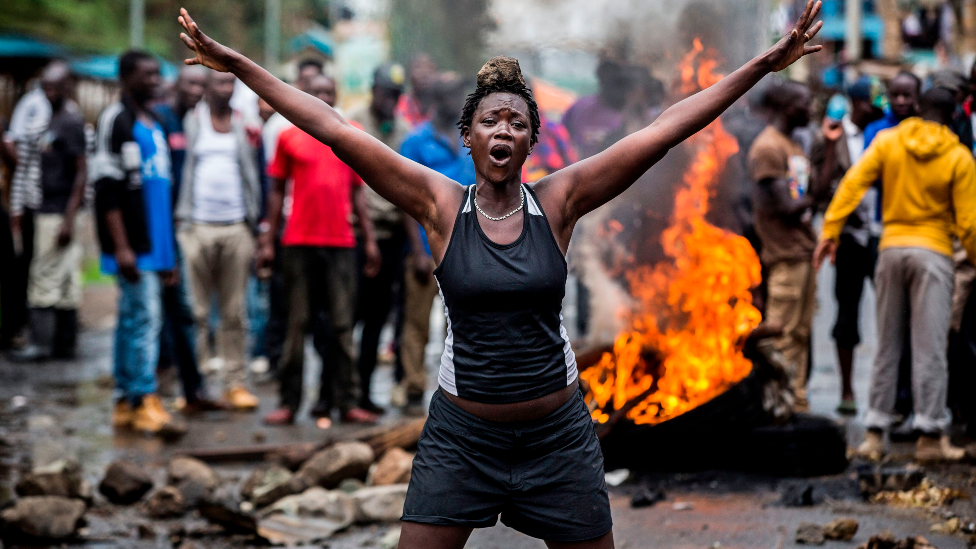 An opposition supporter in front of a burning barricade in Nairobi as a group of demonstrators blocked the road and tried to prevent voters from accessing a polling station during presidential elections - 26 October 2017