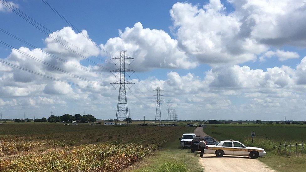 Police cars block access to the site where a hot air balloon crashed early Saturday, July 30, 2016, near Lockhart, Texas