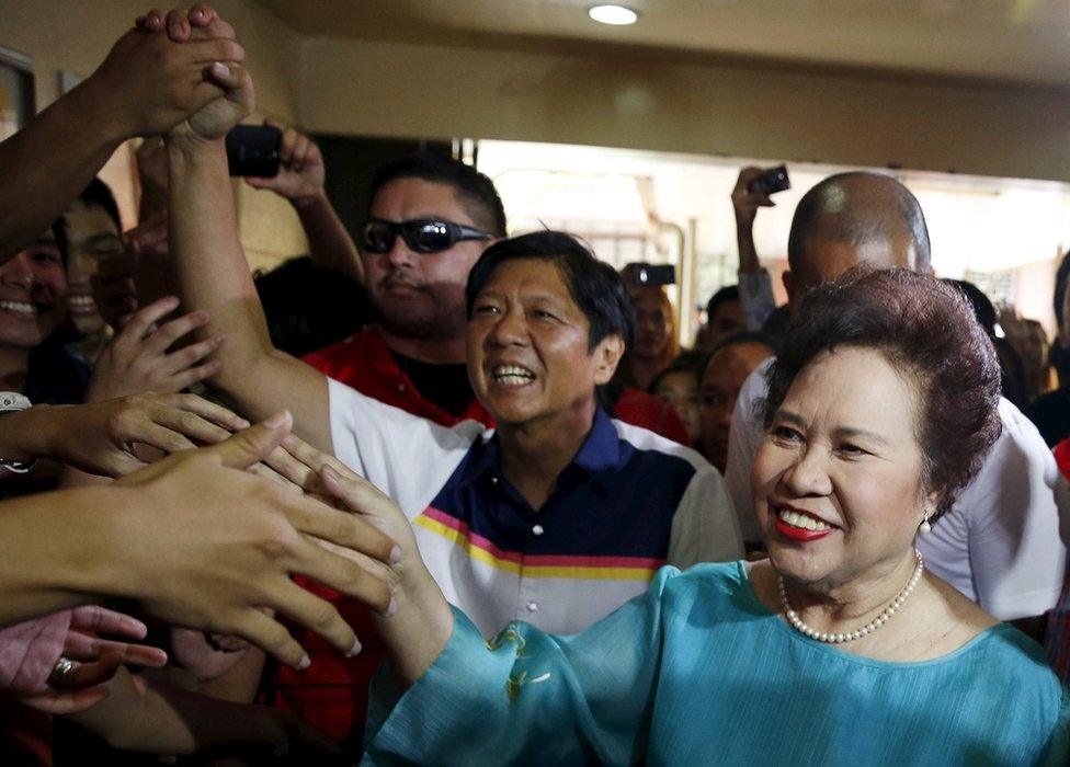 Philippine presidential candidate Miriam Santiago and running mate vice presidential candidate Ferdinand "Bongbong" Marcos (C) greet supporters during an election campaign for the May 9 election, in the mountain resort of Baguio city in northern Philippines 16 April 2016