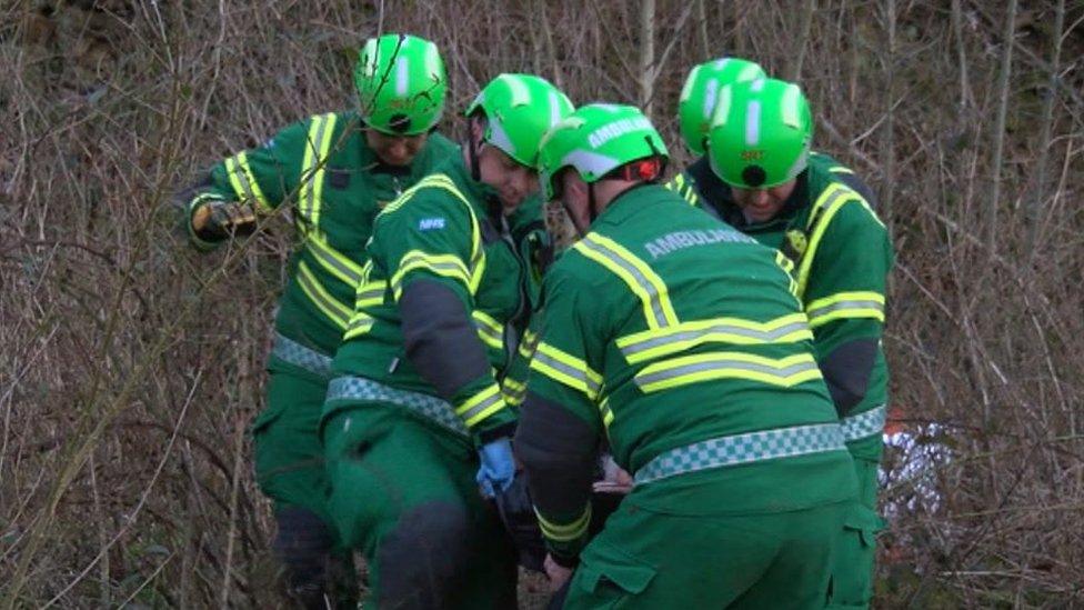 Paramedics carrying a monitor away