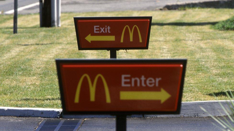 McDonald's enter and exit signs outside a restaurant