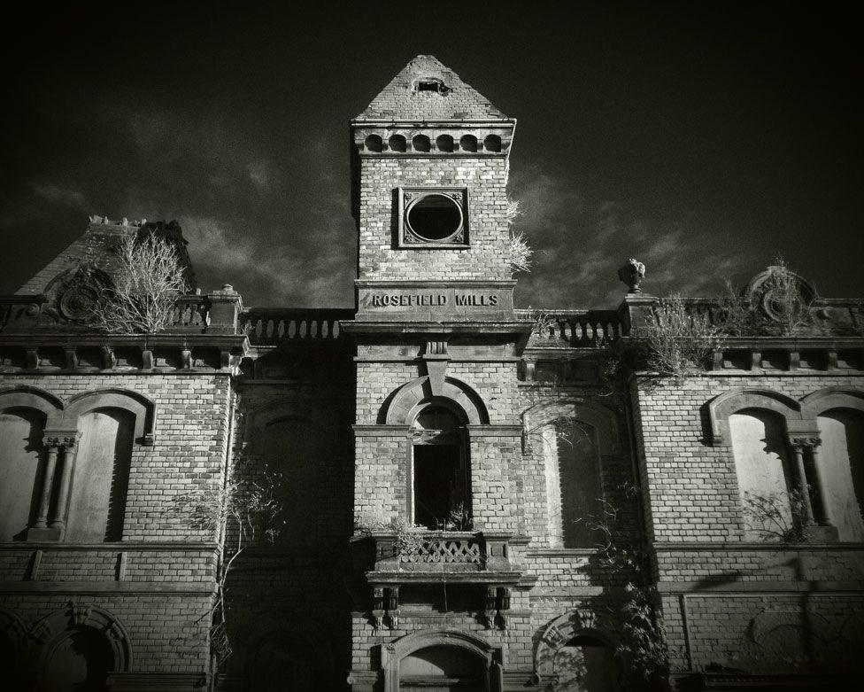 A black and white slightly eerie image of the brick front of the Rosefield Mills building