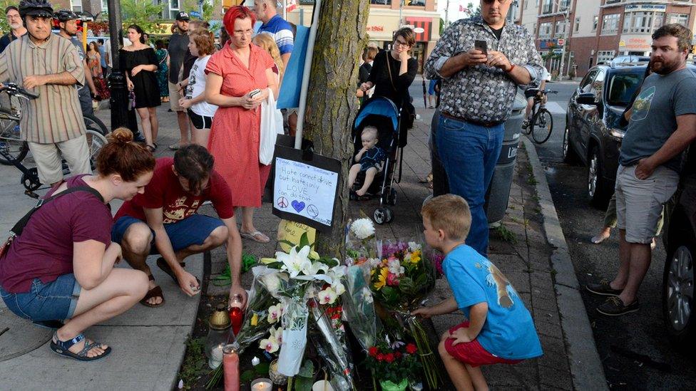 Residents of the Danforth area leave flowers and light candles for the victims