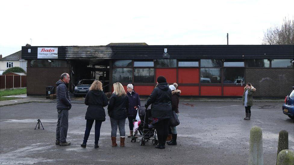 Local people gather outside the damaged building.
