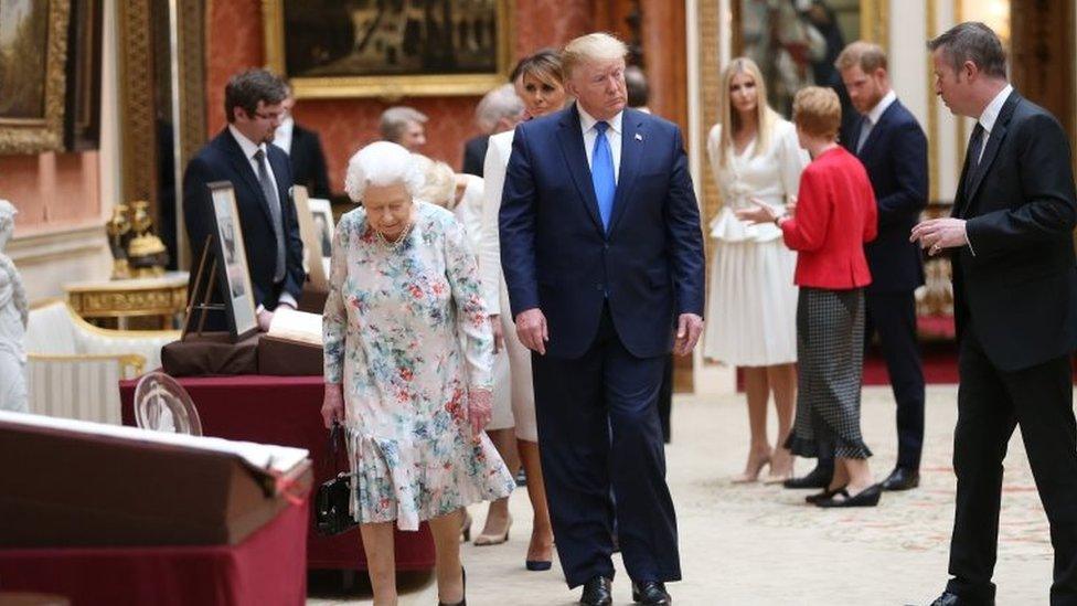 Queen Elizabeth II (L) and US President Donald Trump (2nd L) view American items in the Royal collection while Ivanka Trump (4th R) daughter of US President Donald Trump, speaks with Prince Harry, Duke of Sussex (2nd R) at Buckingham Palace on 3 June 2019 in London, England