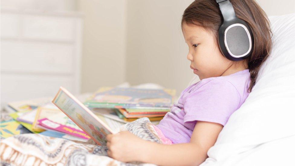 Child reading in bed.