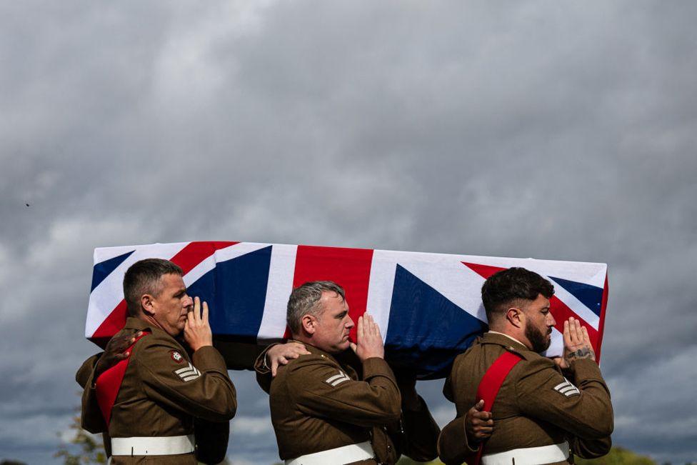 Soldiers from the Royal Regiment of Scotland carry the coffin of one of the two unidentified Scottish soldiers who died during World War I, as they are buried during a funeral service at the Loos British Cemetery of the Commonwealth War Graves Commission (CWGC) in Loos-en-Gohelle, near Lens, northern France, on Septmber 26, 2024. 