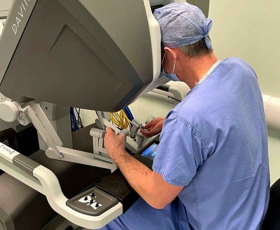 Prof Roxburgh operates the four robot arms from a console within the theatre