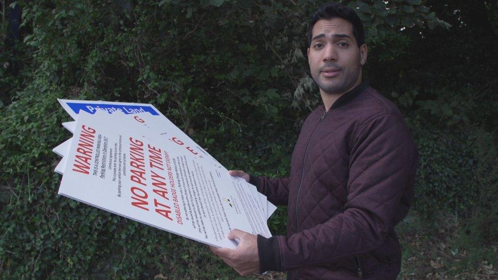 Omar Hamdi from BBC Wales' X-Ray with some of the parking signs