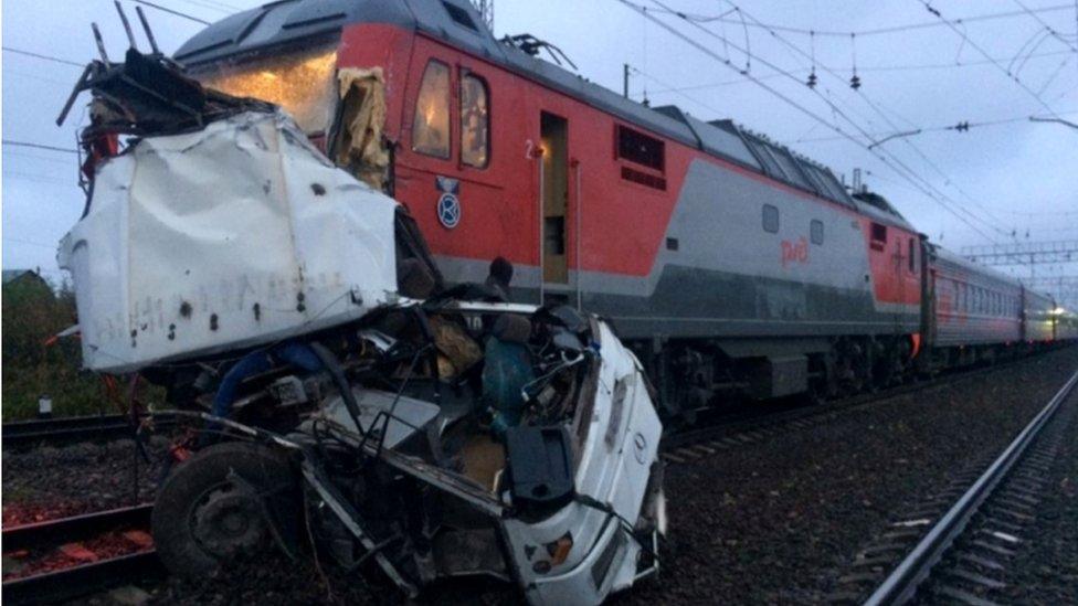 Wreckage of bus attached to the front of passenger train