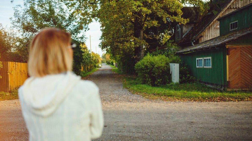 Stock image of a woman looking at a barn