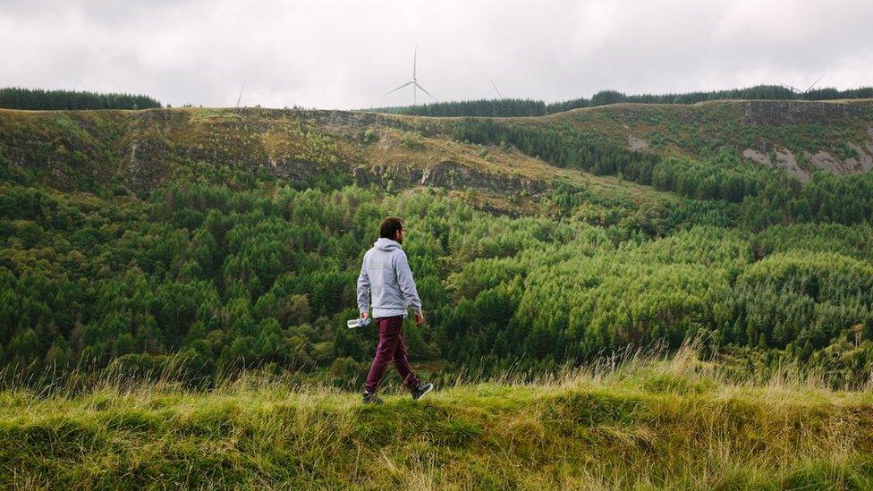 Ian Thomas walking on a hill