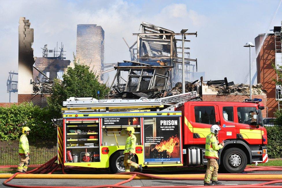 Firefighters near the wreckage of the building the day after the fire