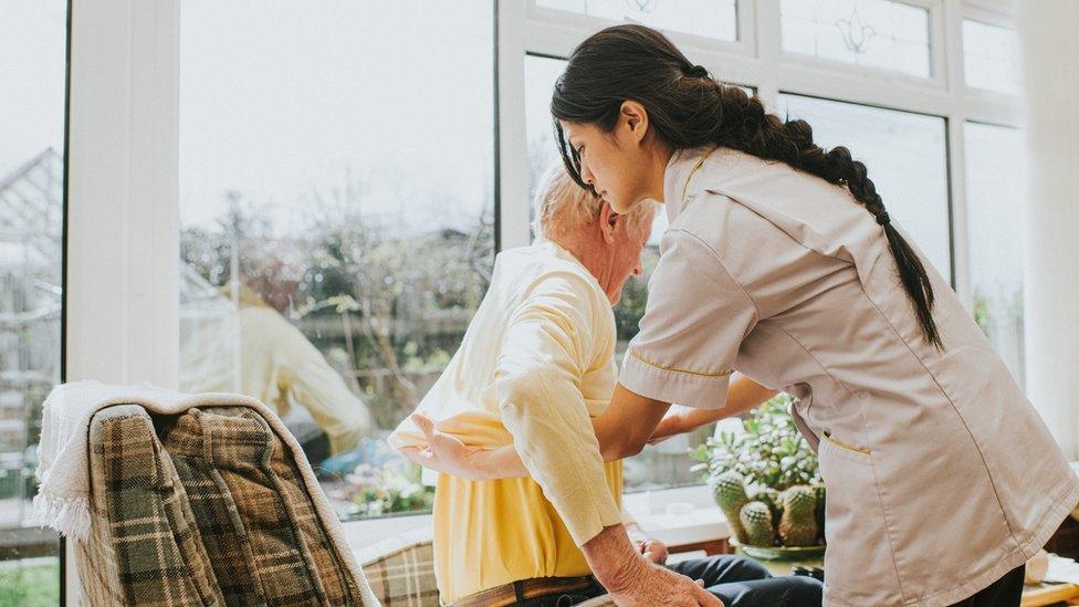 Care home worker helps resident