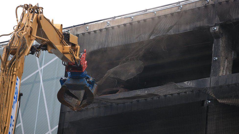 A crane outside a blackened burnt out car park